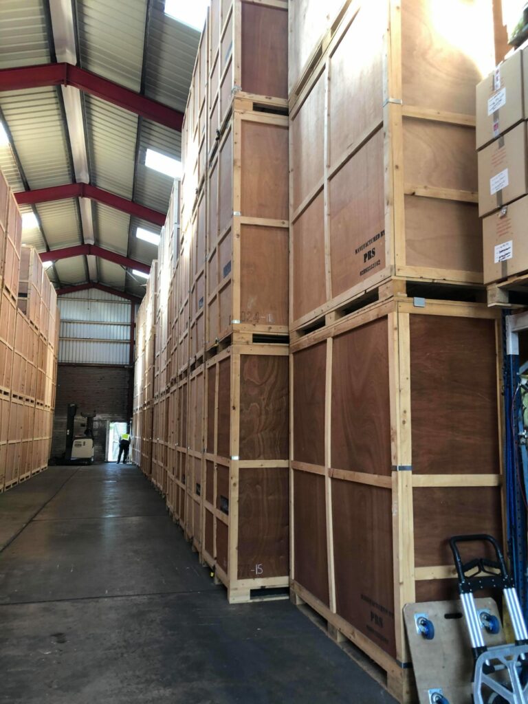 Rows of large wooden crates stacked in a warehouse.