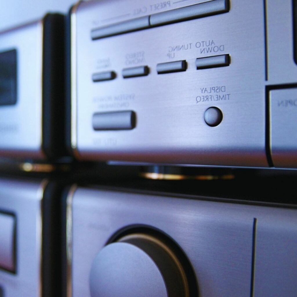Close-up of a silver stereo system with focus on the cd player and control buttons.