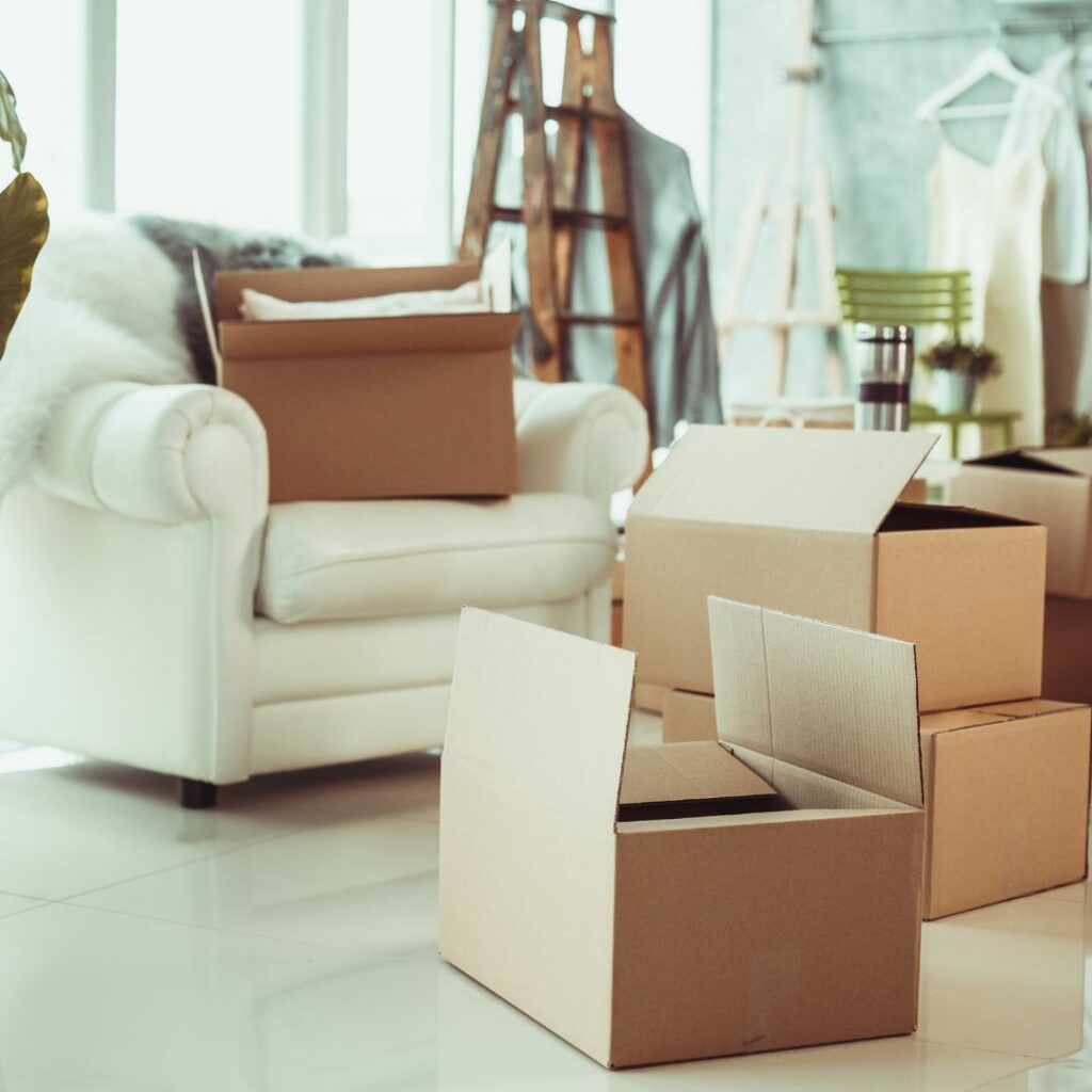 Cardboard boxes on the floor of a living room, suggesting moving or unpacking.