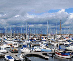 A marina filled with sailboats and vessels under a cloudy sky.