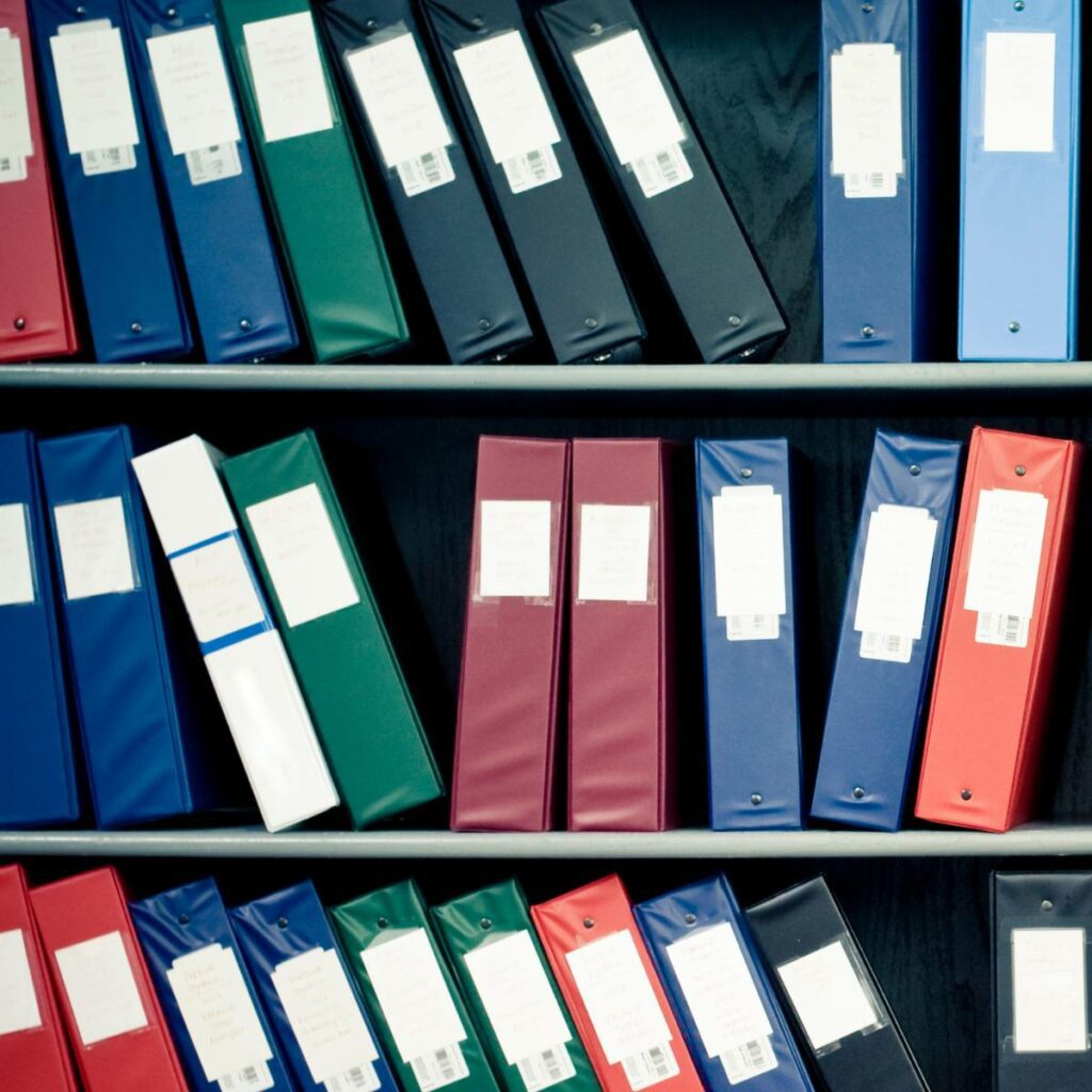 Rows of neatly arranged, colored binders on shelves in a Belfast business.