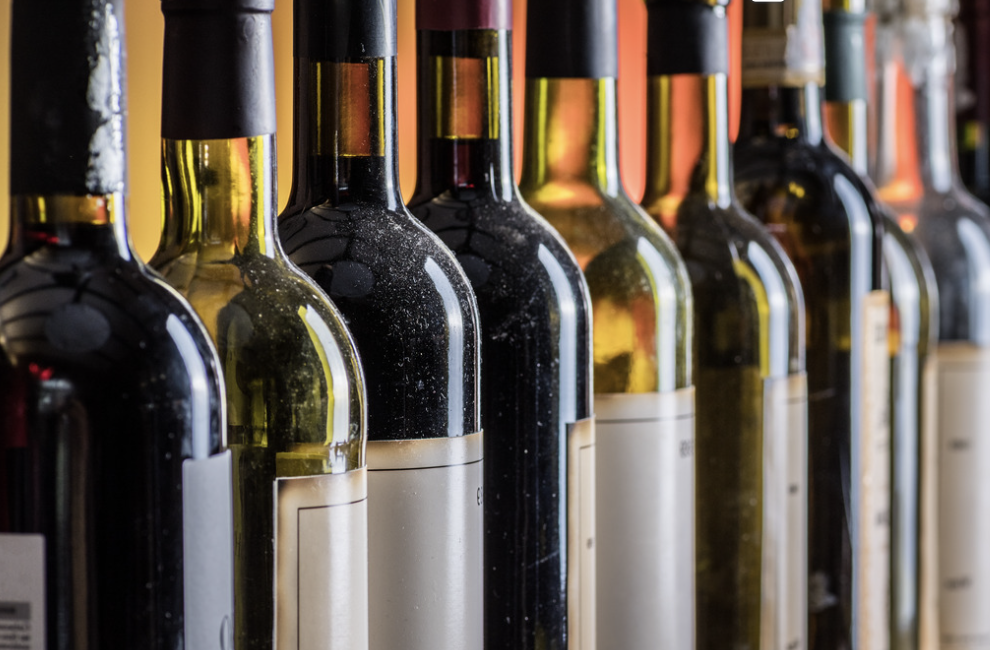 Row of dusty wine bottles in a cellar.