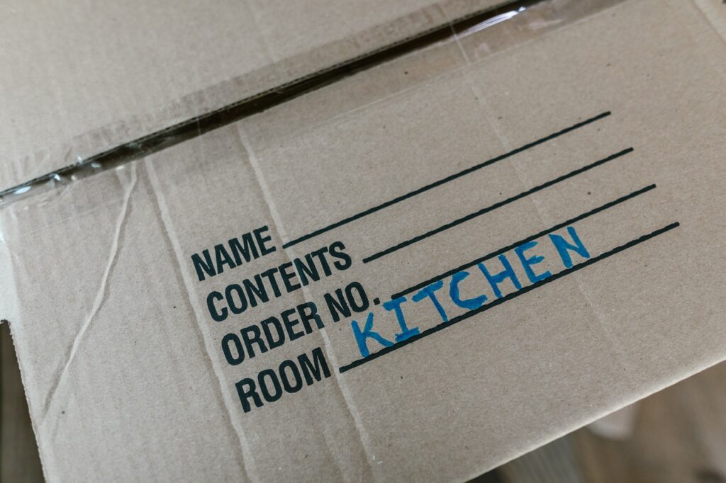 Close-up of a labeled cardboard box indicating it contains kitchen items.