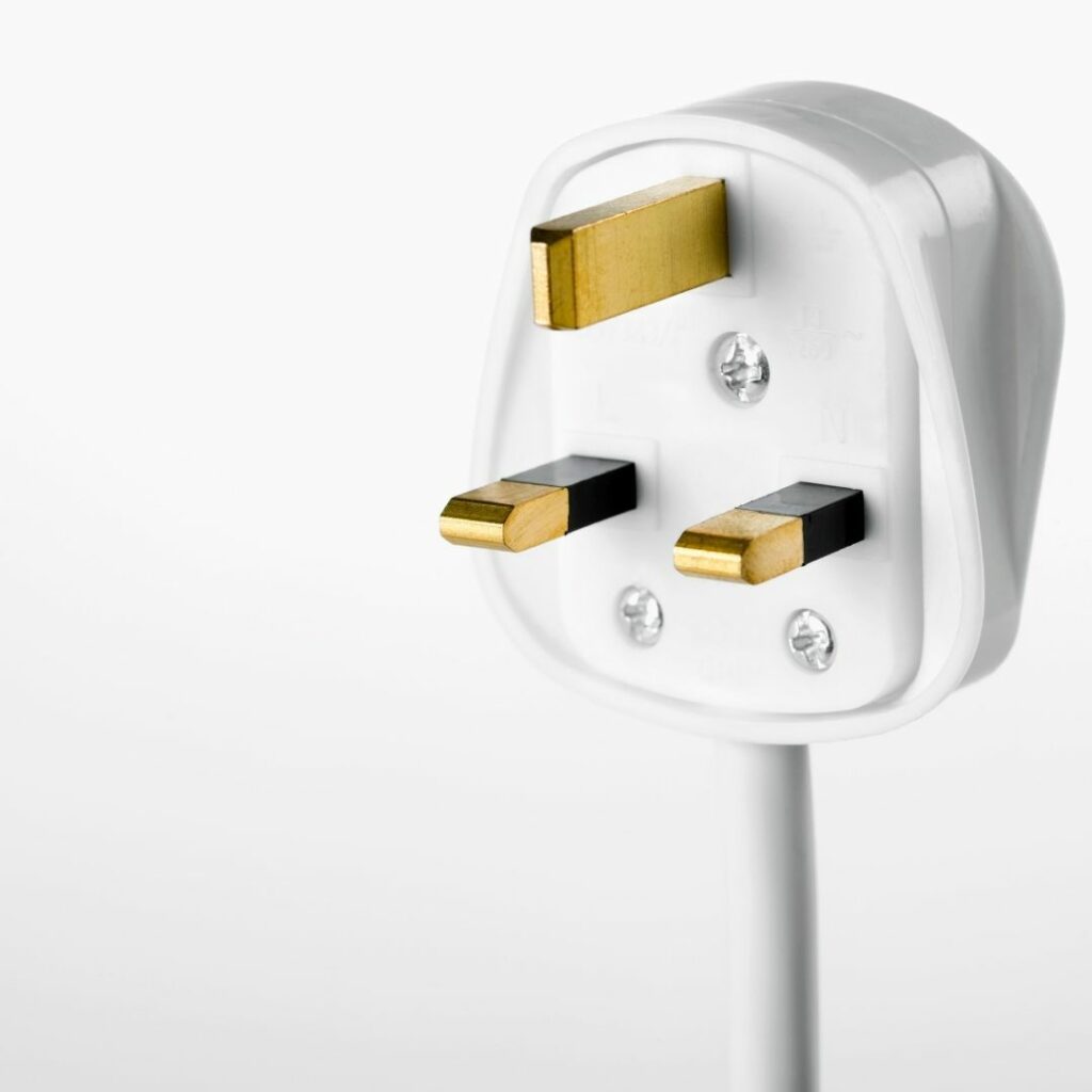 Close-up of a three-pin UK electrical plug against a white background, showcasing ways to make moving day hassle-free.
